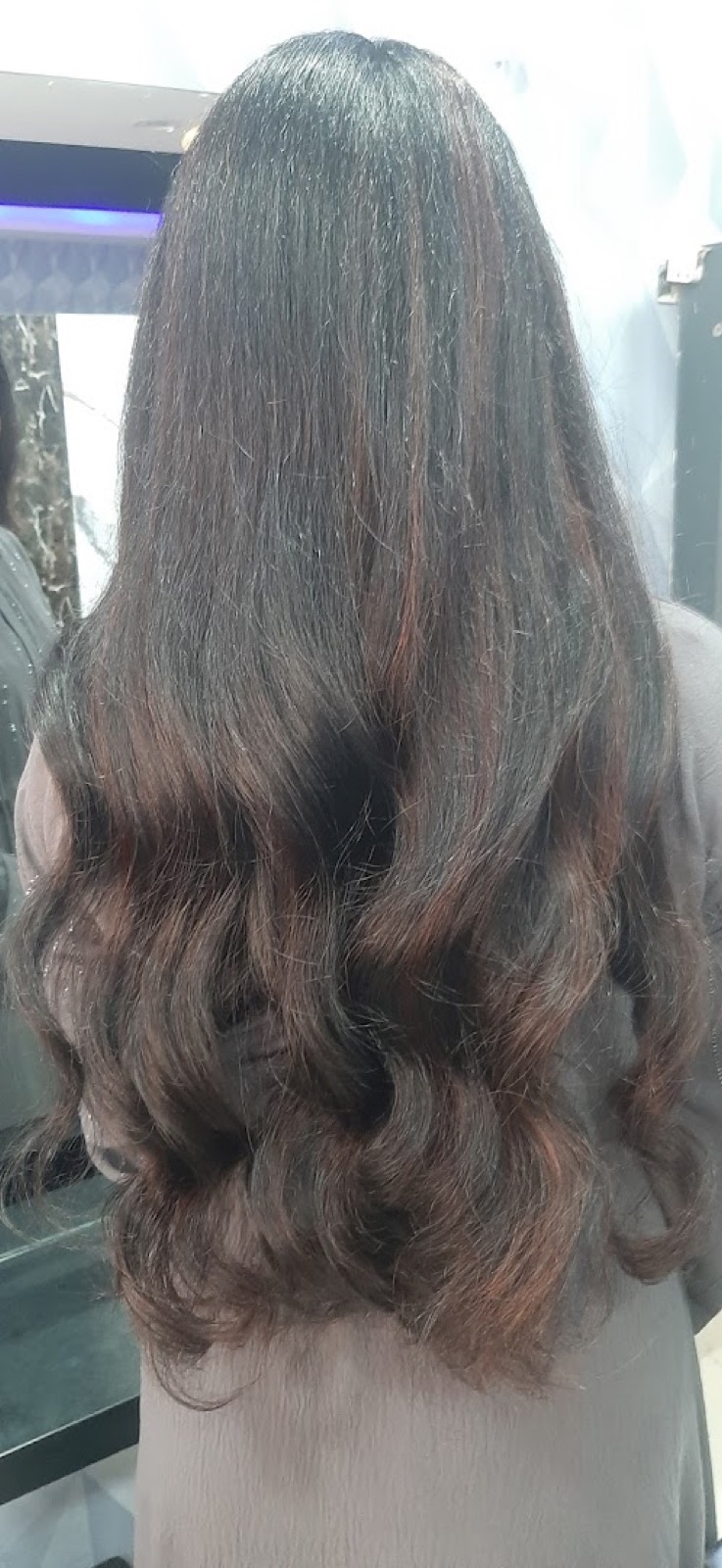 Warm auburn French balayage graduating from a dark root into copper ends, styled in loose waves.