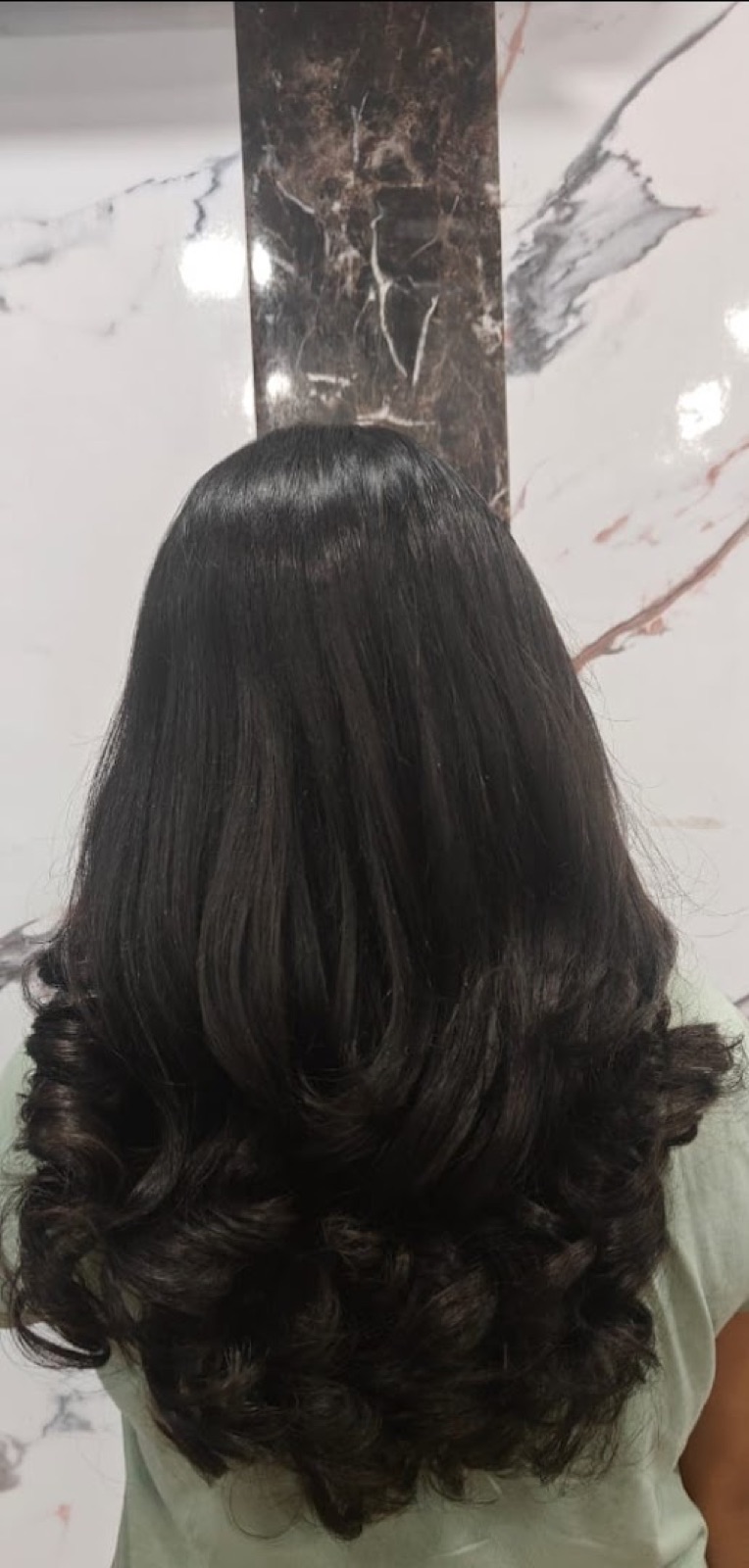 Shoulder-length hair after a permanent straightening treatment, smooth at the crown with a soft curl at the ends.
